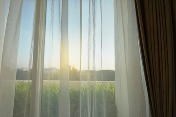 Fototapeta na wymiar sunlight in morning day through white curtain on window