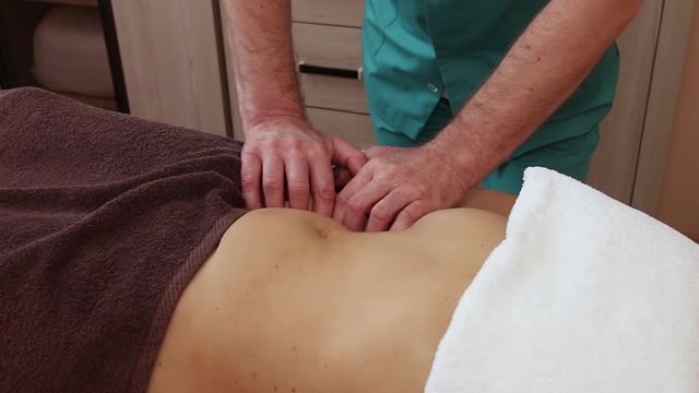 woman having massage in spa salon. Close-up of woman relaxing during back massage lying on massage table 