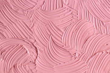 Pale pink cosmetic clay (rhassoul, facial mask, face cream, body wrap) texture close up, selective focus. Abstract background with brush strokes. 