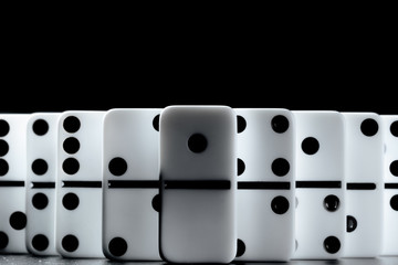Domino pieces put in a row on black background