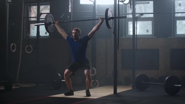 Male bodybuilder doing exercise with heavy weight bar. Full length of fitness man practicing deadlift at health club