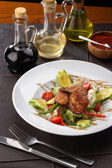 Delicious fresh salad. Salad with chicken, tomatoes, peppers, lettuce on wooden background served with wine. Restaurant food, close up. Meat salad. Close up view on Salad with chicken.