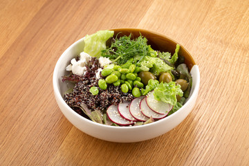 bowl with quinoa, radish, lettuce, beans, olives, cheese. Close up view on healthy, diet tasty summer dish