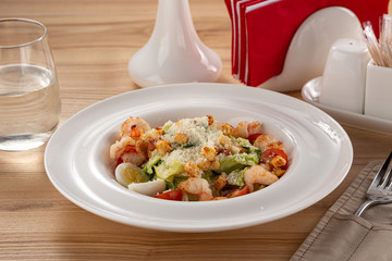 Delicious fresh salad. Shrimp salad, lettuce, arugula, olive oil, cheese, parmesan. fresh healthy avocado and shrimps salad. Close up view on Salad. Healthy, diet tasty summer dish