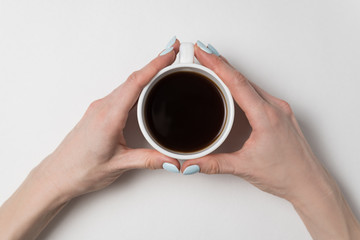 Female hands holding cup of coffee on white background. Mug of tea in female hands.