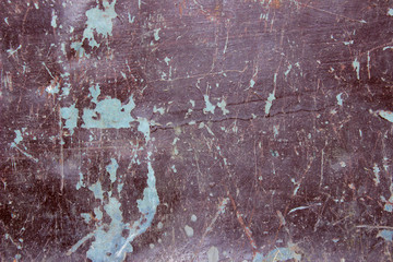 Spots of blue paint on a dark gray iron wall, blurry image. Abstract texture background.