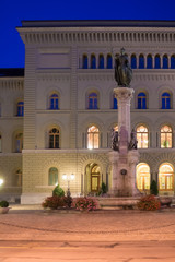 Fountain on street in old city center of Bern, Switzerland. Illuminated late in the evening