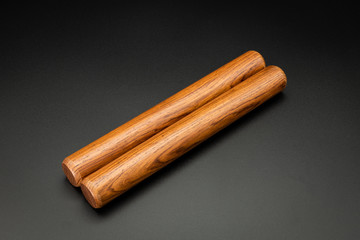 A pair of wooden claves lying on a black underground