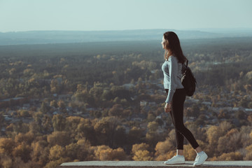 Girl stands on a hill and looks into the distance on the forest. © somemeans