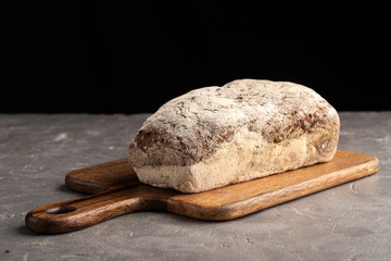 A traditional square loaf of bread. One whole fresh baked bread on stone table. Fresh homemade baked bread
