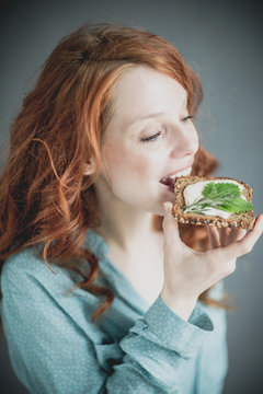 young woman eating vegan sandwich