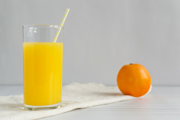 Fototapeta premium Orange juice with fruit on light wooden background