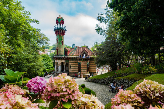 Capricho de gaud&iacute; con flores por abajo dia claro con nubes