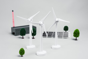 Three wind turbines and solar panel on white background