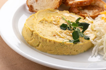 Hummus with olive oil. Hummus platter with assorted snacks. Hummus in bowl