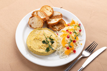 Hummus with olive oil. Hummus platter with assorted snacks. Hummus in bowl