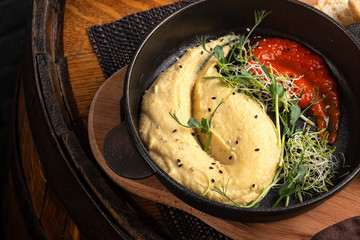 Hummus with olive oil. Hummus platter with assorted snacks. Hummus in bowl