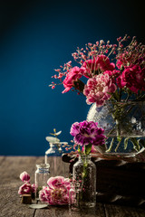 Bouquet of pink carnation in glass vase on dark blue background. Mothers day, birthday greeting card. Copy space.