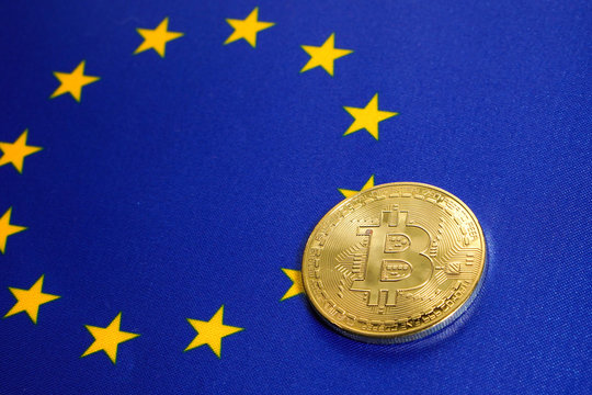 Golden Bitcoin on the flag of European Union. Close-up, copy space