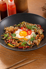 Thai food fried rice with egg. Asian cuisine-Homemade egg fried rice served with vegetables. Fried rice with vegetables, pepper, carrot, cucumber, parsley, onion, eggs, chilli. Indo-chinese cuisine