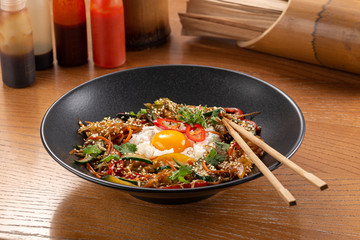 Thai food fried rice with egg. Asian cuisine-Homemade egg fried rice served with vegetables. Fried rice with vegetables, pepper, carrot, cucumber, parsley, onion, eggs, chilli. Indo-chinese cuisine