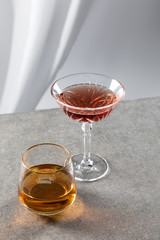 red wine near glass of cognac on white