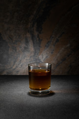 cognac in glass on textured granite background