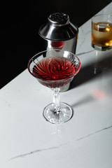 selective focus of red wine near shaker and glass with whiskey isolated on black