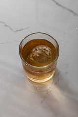top view of glass with whiskey on white marble surface