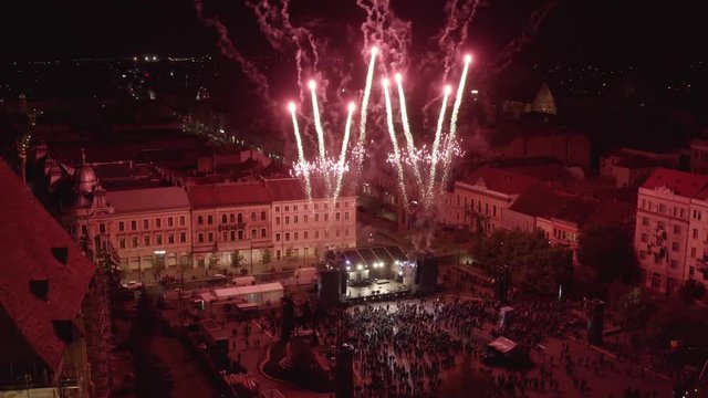 Aerial shot above and open-air stage at night. City center pyrotechnics and fireworks