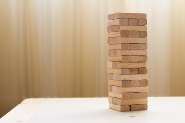Tower of wooden blocks. Board game jenga. The concept of education, risk, development and growth. Place for the test. Games for children and parents.