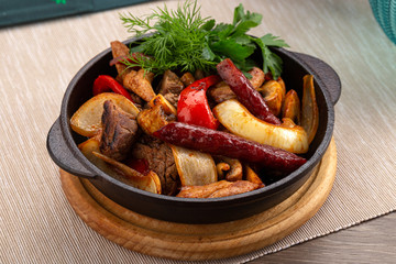 Home-made Pork Sausages in rustic pan. Sausages cooking in frying pan. Close up of fried sausages in frying pan over wooden background