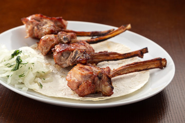 Grilled Food. Barbecue. Lamb rack roasted with herbs. Grilled roasted rack of lamb, veal with vegetables