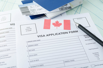 Concept of getting canadian visa. Blank visa application form, pen, passports, tickets and canadian...