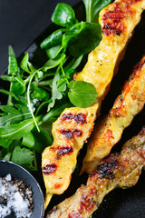 Close up Grilled chicken and pork Curry Skewers, kebabs with spices, herbs on dark background, copy space. Keto Paleo. Pegan Diet.