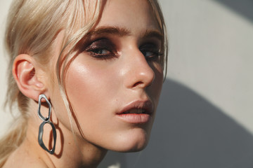 Fashion beauty portrait of young beautiful woman wearing earrings. - obrazy, fototapety, plakaty