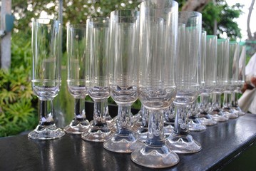 Rows of clear water goblets lined up on a table