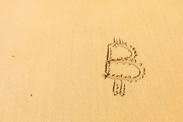 Image of icon bitcoin cryptocurrency on golden sand with sea water background. Concept freelance, stock exchange BTC sign hand written at sandy beach. Unstable rise and fall of concept, top view