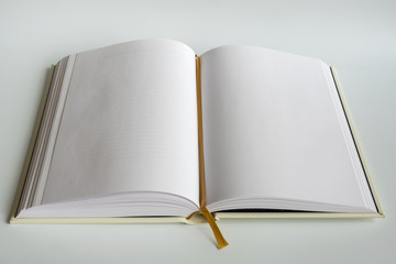 Opened blank hardcover book with ribbon bookmark. Isolated on a white background..