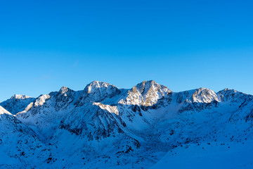 Fototapeta na wymiar Montañas con nieve en andorra y cielo azul despejado