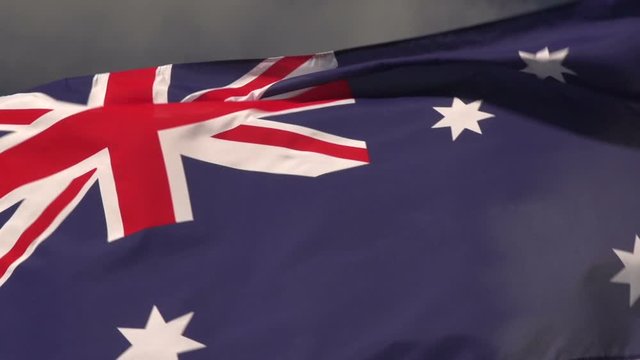 Australia Flag flying in the wind outside with Blue sky Behind - Australian flag in Super slow motion, Close up