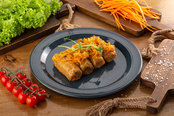 cabbage rolls stuffed with ground beef and rice served on a plate on an old rustic table. Stuffed cabbage leaves with minced meat and rice in tomato sauce.