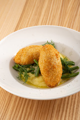 Chicken Kiev cutlets with parsley leaves. Ukrainian tradition food. Chicken Kiev, ukrainian cuisine. Chicken cutlet in bread crumbs stuffed with butter and herbs, served with mashed potato. Close up