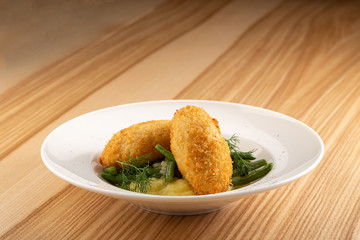 Chicken Kiev cutlets with parsley leaves. Ukrainian tradition food. Chicken Kiev, ukrainian cuisine. Chicken cutlet in bread crumbs stuffed with butter and herbs, served with mashed potato. Close up