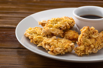 nuggets with sauce. Chicken breast nuggets. Plate with tasty nuggets and sauce on wooden table. Close up