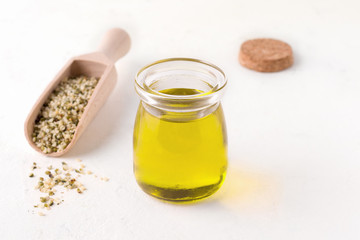 hemp oil next to peeled hemp seeds on a white background. Have copy space