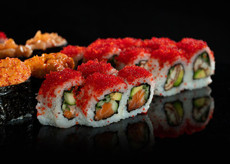 Japanese Sushi isolated on black background. Reflection in a mirror surface. Close up. Studio photo.