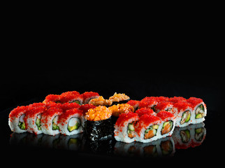 Japanese Sushi isolated on black background. Reflection in a mirror surface. Close up. Studio photo.