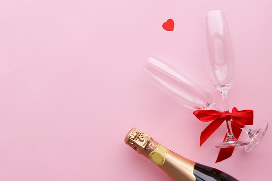 A bottle of champagne for Valentine's Day, a pink background, space for text