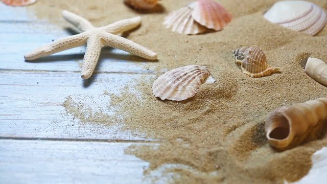 sea shells and starfish on a blue wooden background and sand. The concept of summer vacation